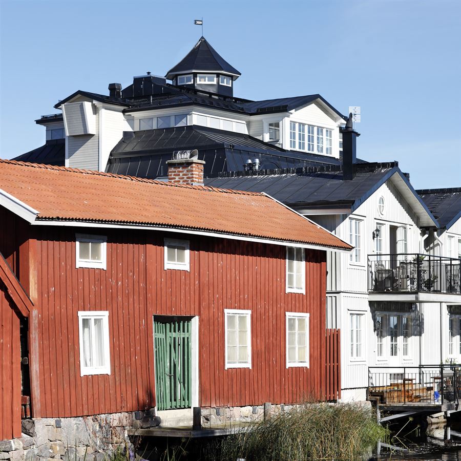 Hus i olika färger längsmed ett vattendrag.