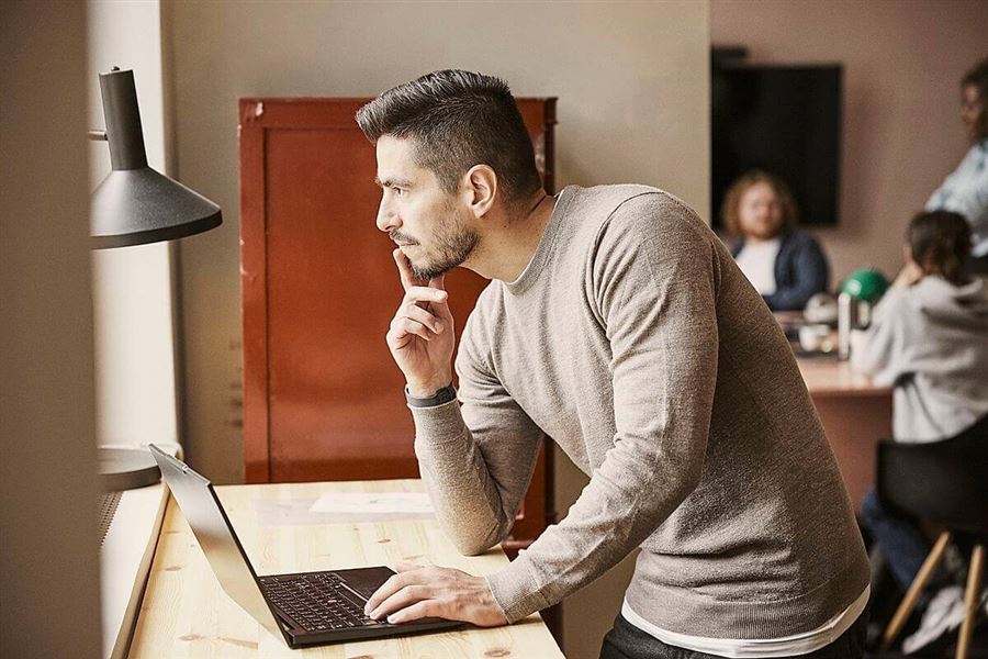 En man sitter vid sin dator och hanterar företagets tjänstepension.