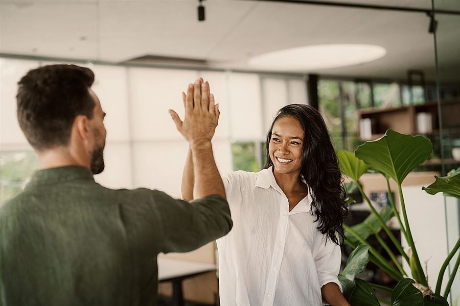 Glada kollegor ger varandra en high five.