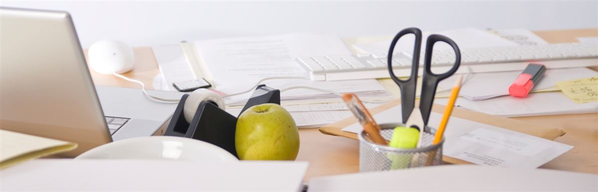 a workdesk with a laptop and papers on it