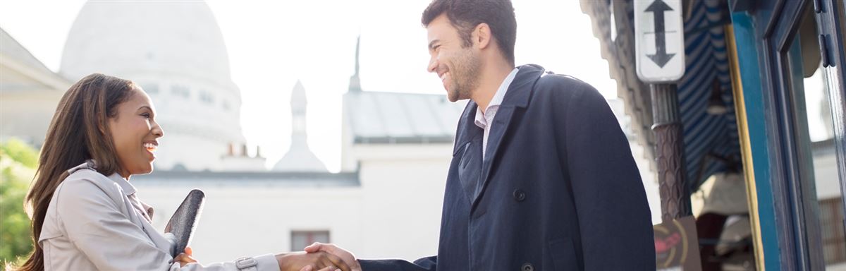 a woman and a man meeting and shaking hands