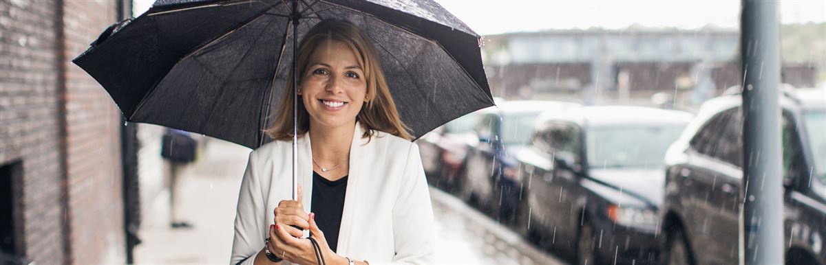 a woman walking in the rain with an umbrella in her hand