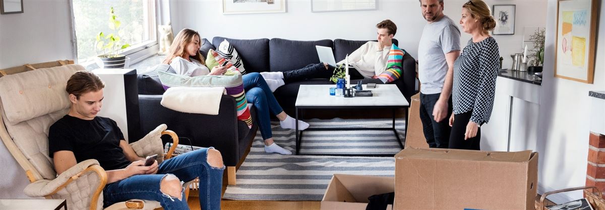 en familj i ett vardagsrum med flyttkartonger i rummet