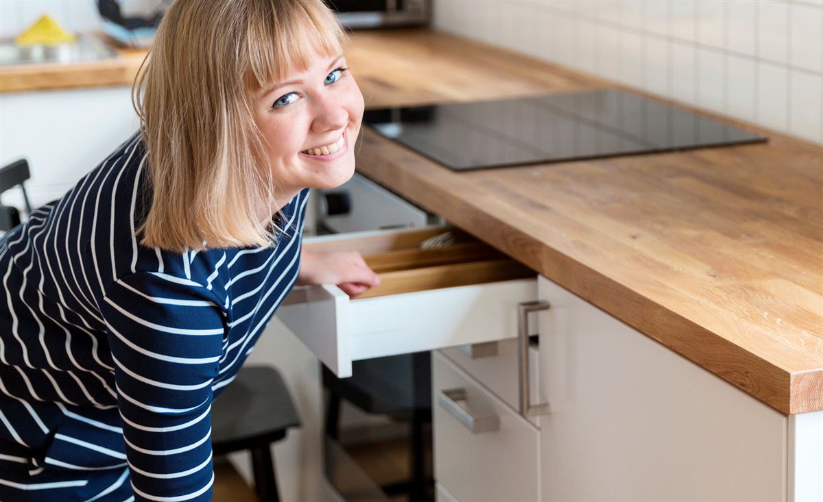 en tjej drar ut en låda i ett kök