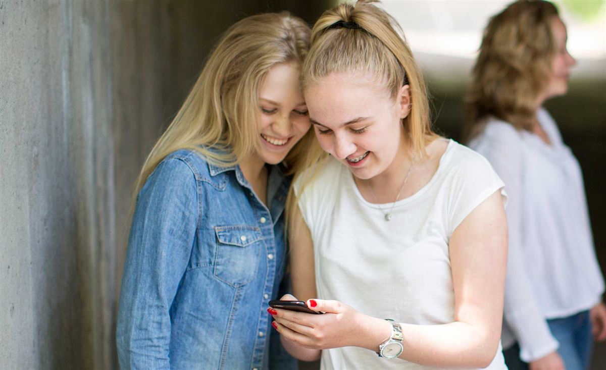 Två tjejer tittar i sin telefon