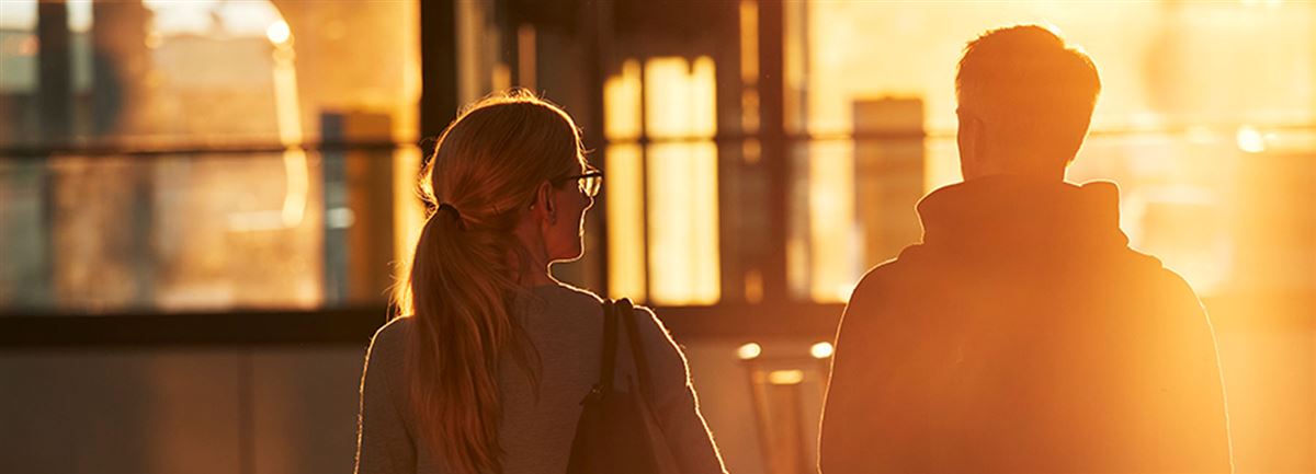 Woman and man at a train station in sunset.
