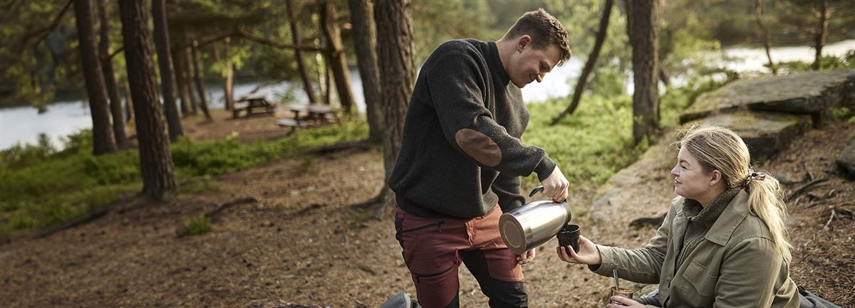 Par i skogen som tar en kaffekopp i skogen