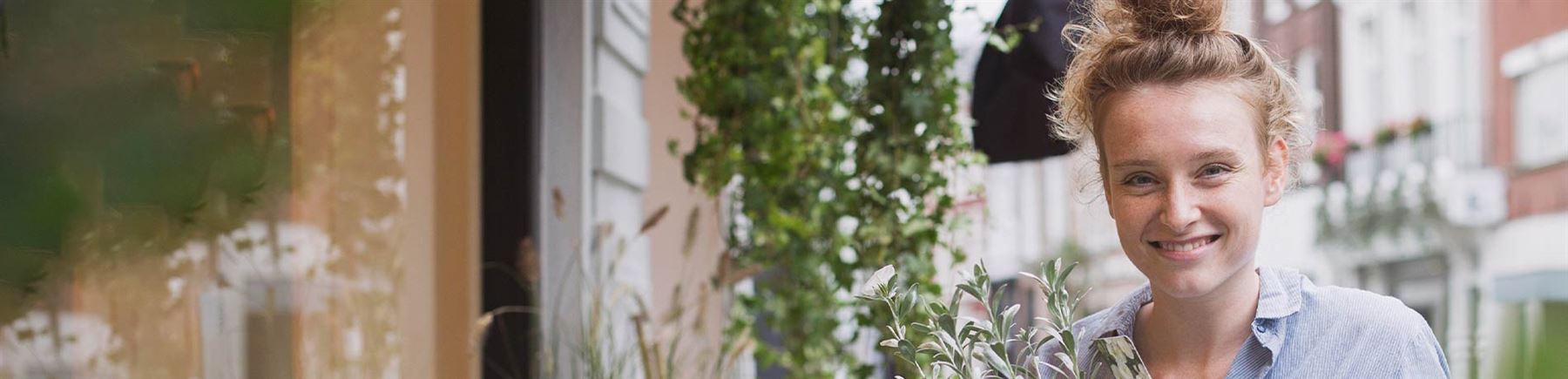 A florist is arranging flowers outside of her shop.