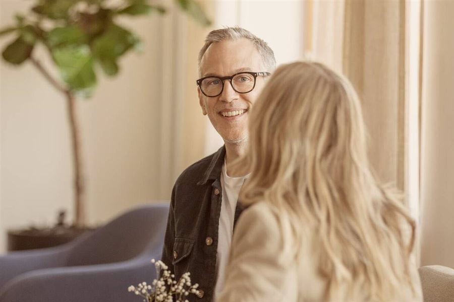 Man in glasses looking at a girl smiling.