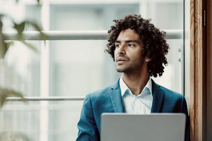 Thinking man with in front of laptop.