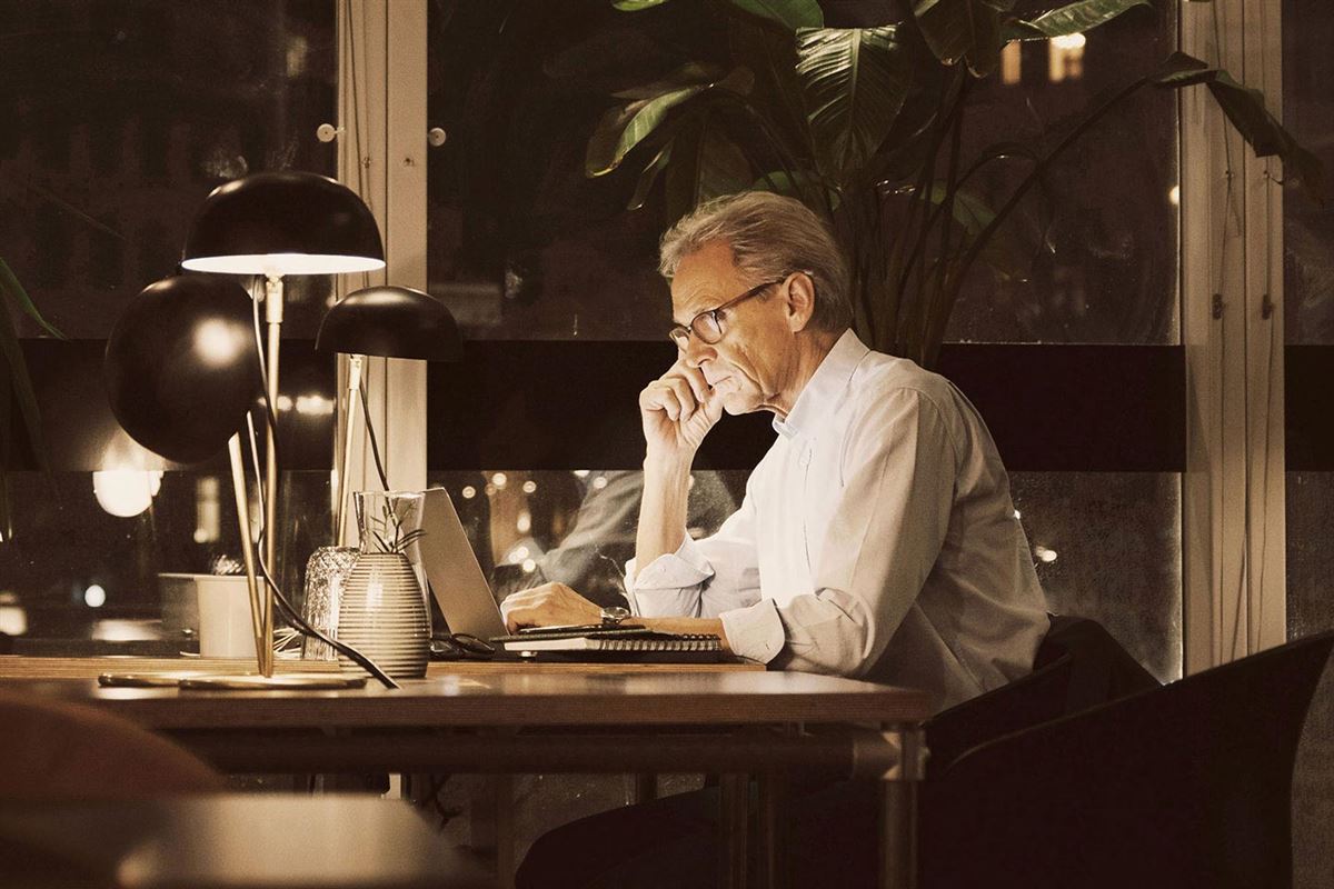 Man with laptop in darkness.