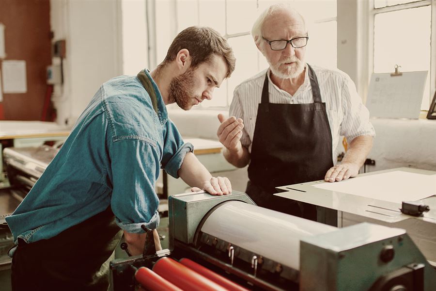 Two men working on a letterpressmachine.