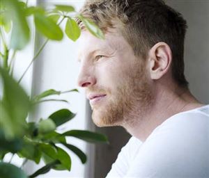 Man tittar ut genom fönstret